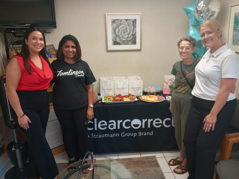 Patients and clear correct representatives standing in front of display table