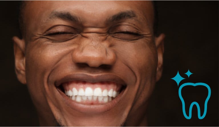 A man smiling, showcasing his bright, white teeth after a successful whitening treatment.